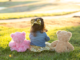 Child In A Bow Sitting In Between Two Teddy Bears